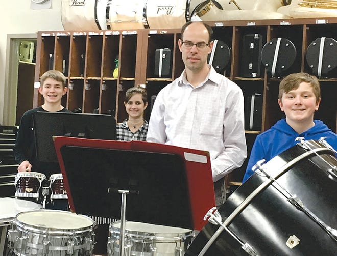 Greencastle-Antrim Middle School instrumental music teacher, Dr. Eric Plum, shares his love of music with, from left, eighth-graders Corey Mowen and Cora LaPlante, and sixth-grader Larson Thomas, in the school's band room.
